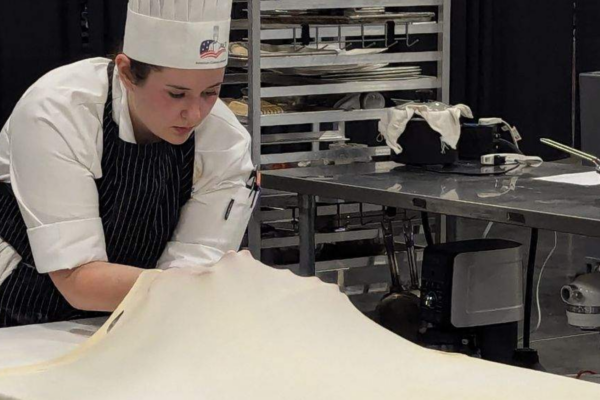 student chef stretching dough